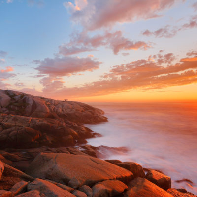 Beautiful Peggy Cove Light House with Sunset, Nova Scotia, Canada. Photo shows tourists watching sunset.