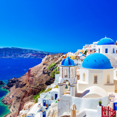 Oia town on Santorini island, Greece. Traditional and famous houses and churches with blue domes over the Caldera, Aegean sea