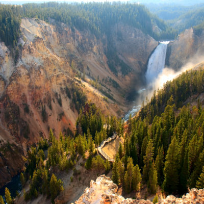 Sunlight illuminates the spray as the Yellowstone River crashes over the Lower Falls in Yellowstone's Grand Canyon.