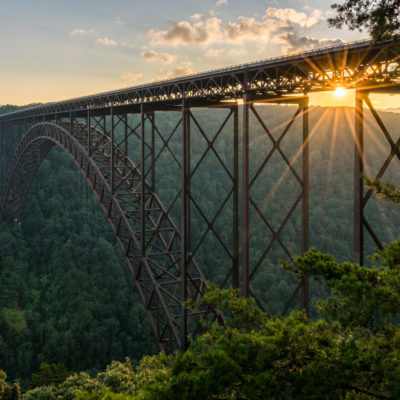 Setting sun behind the girders of the high arched New River Gorge bridge in West Virginia